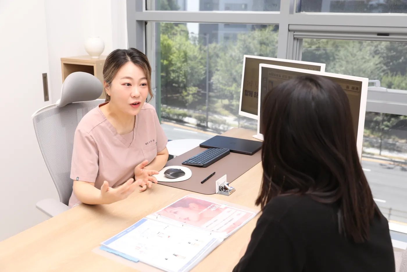 창가 진료실에서 환자와 상담하는 안우경 대표원장