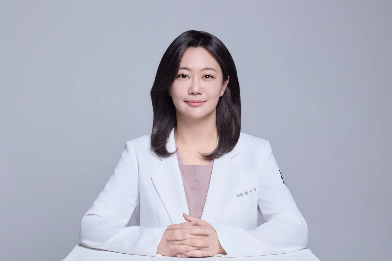 테이블에 손을 모으고 앉아 있는 피어리움의원 안우경 대표원장